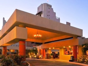 Experience the sleek, modern design of this hotel, featuring a striking overhang structure and inviting outdoor seating areas.