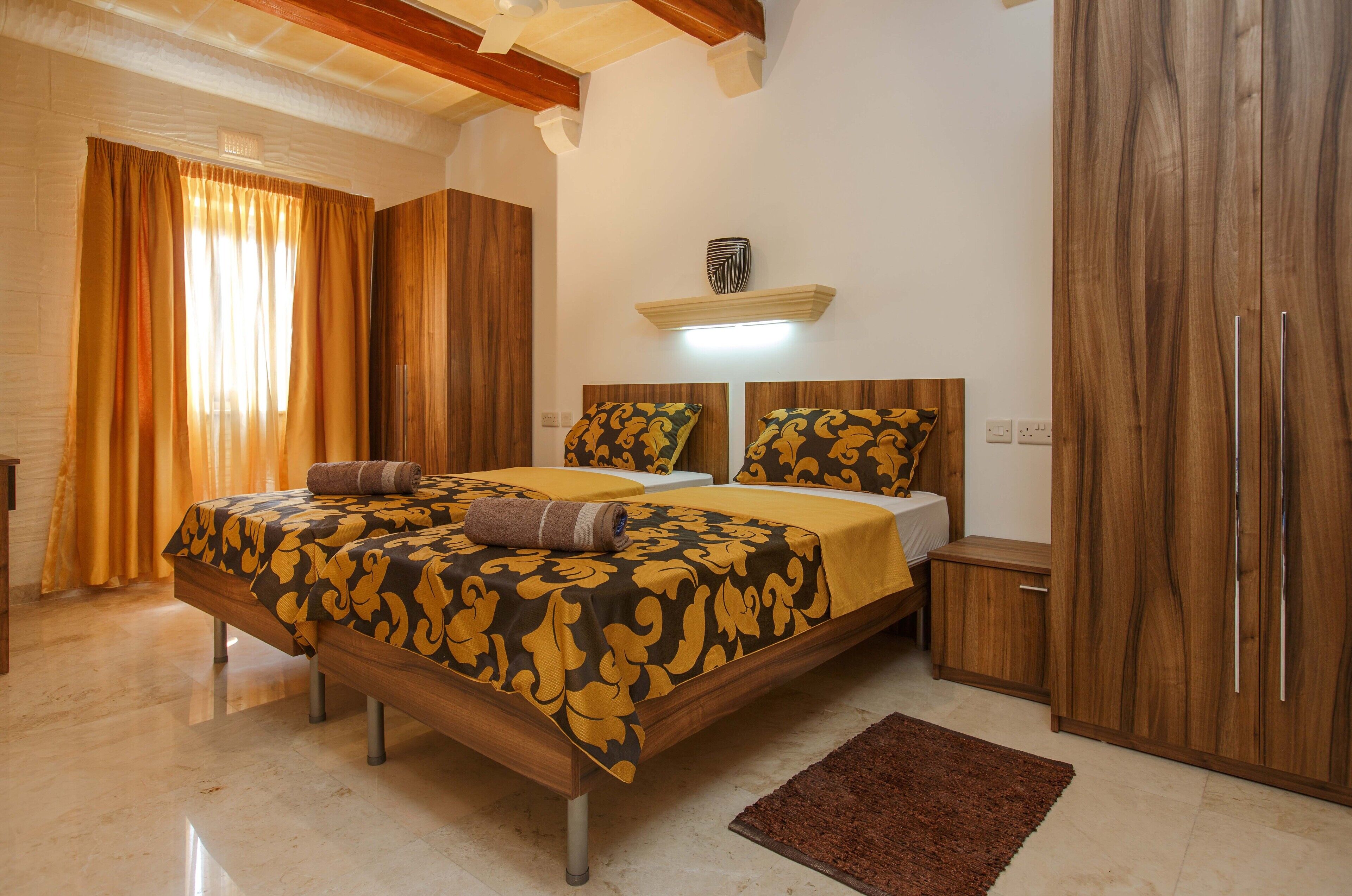 A bedroom with a wooden bed, a nightstand, a wardrobe, and a bedside table.