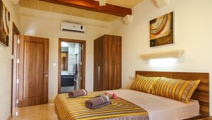 Habitación de hotel con cama, armario de madera y un cuadro en la pared.