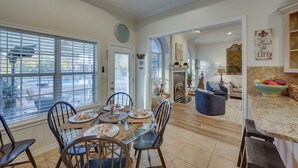 A dining area with a glass table, chairs, and a view through large windows. - 'The Crown Goose' - Bullard Home w/ Pool & Spa! (Bullard)