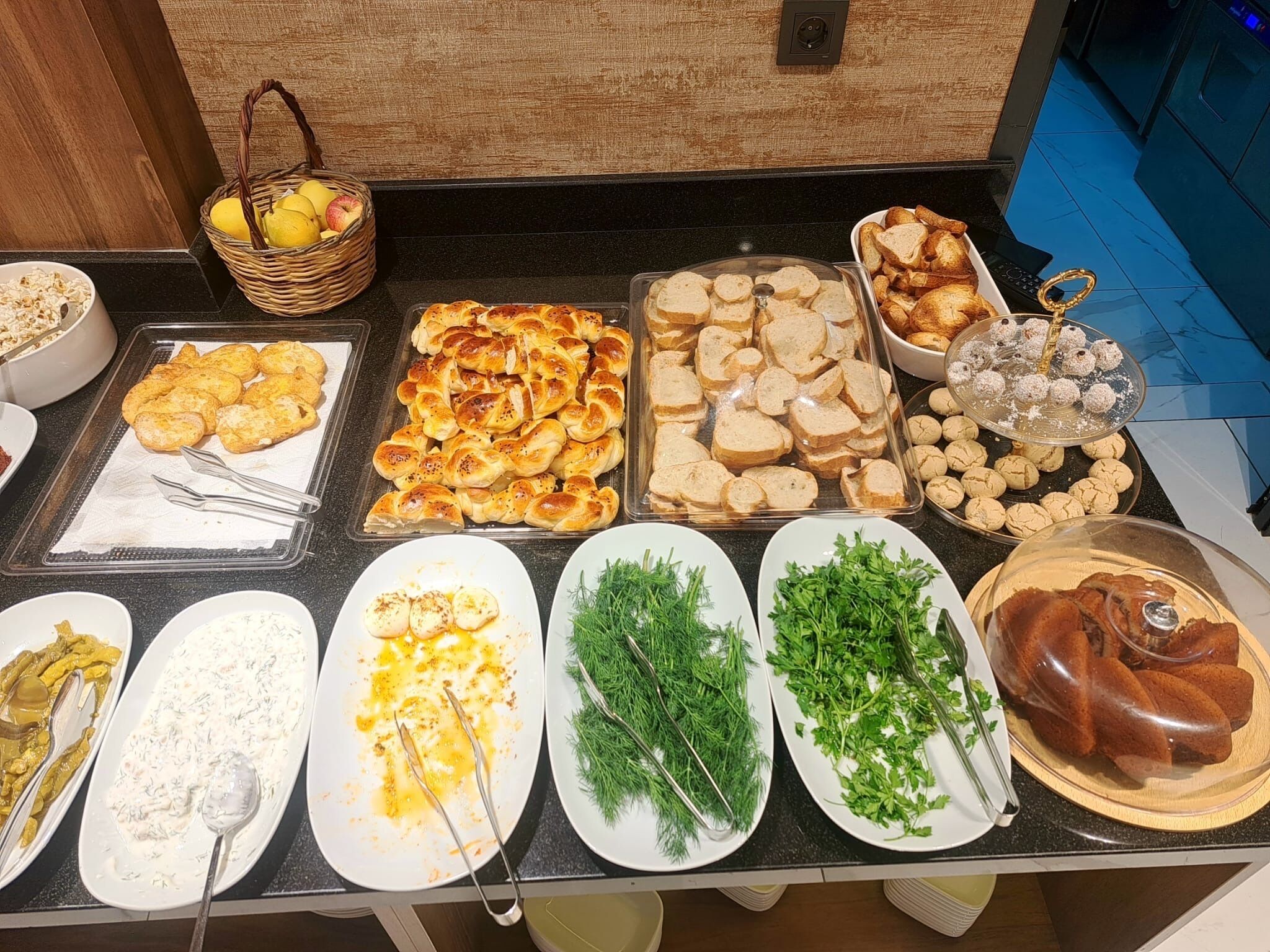A buffet with various food items including bread, pastries, and salads.