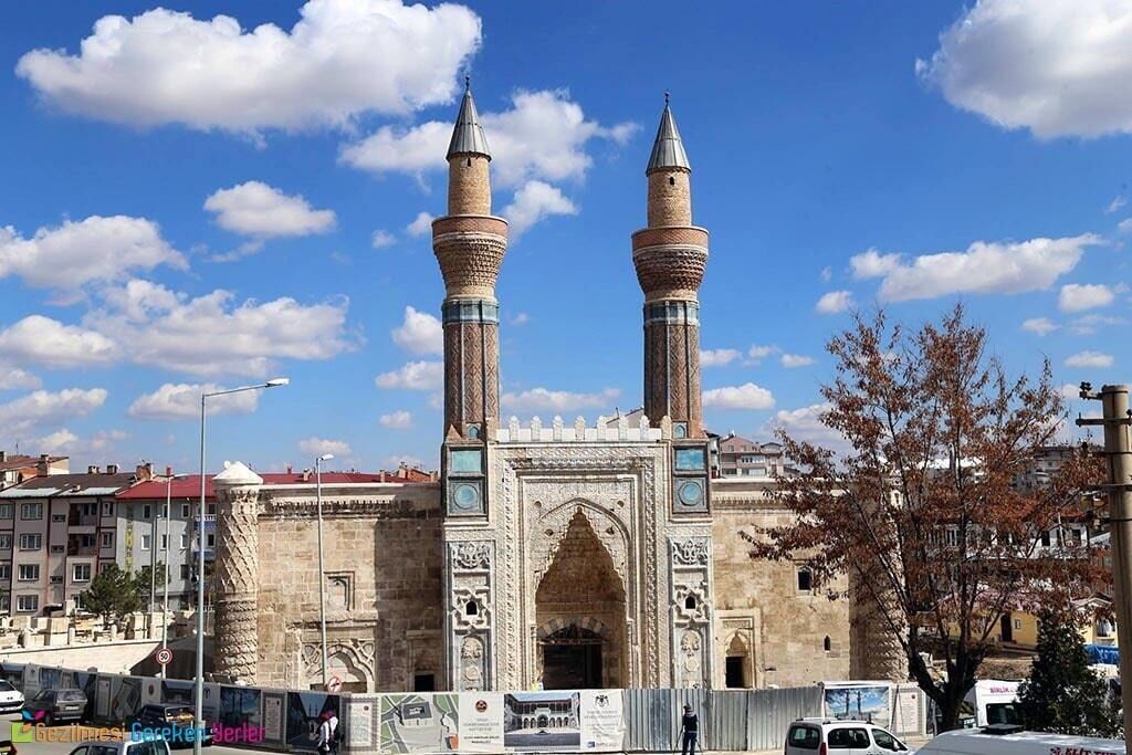 Un edificio histórico con dos imponentes minaretes y una entrada ricamente decorada.