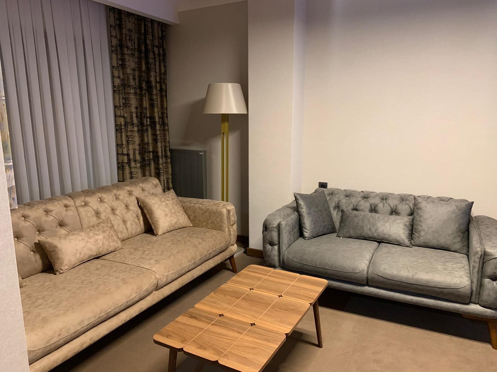 A living room with two sofas, a lamp, and a wooden coffee table.