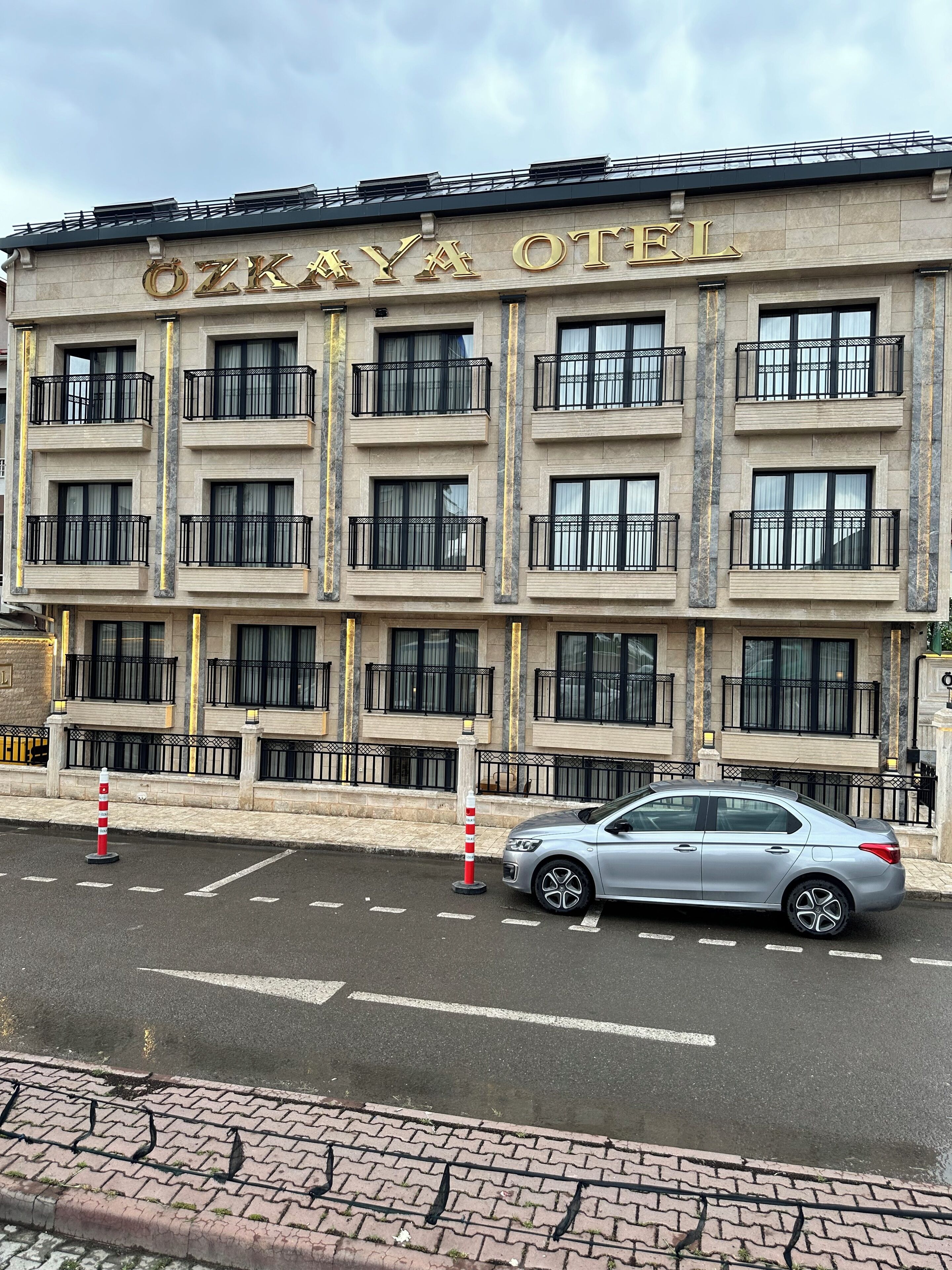 Ein mehrstöckiges Gebäude mit Balkonen und ein Auto davor.