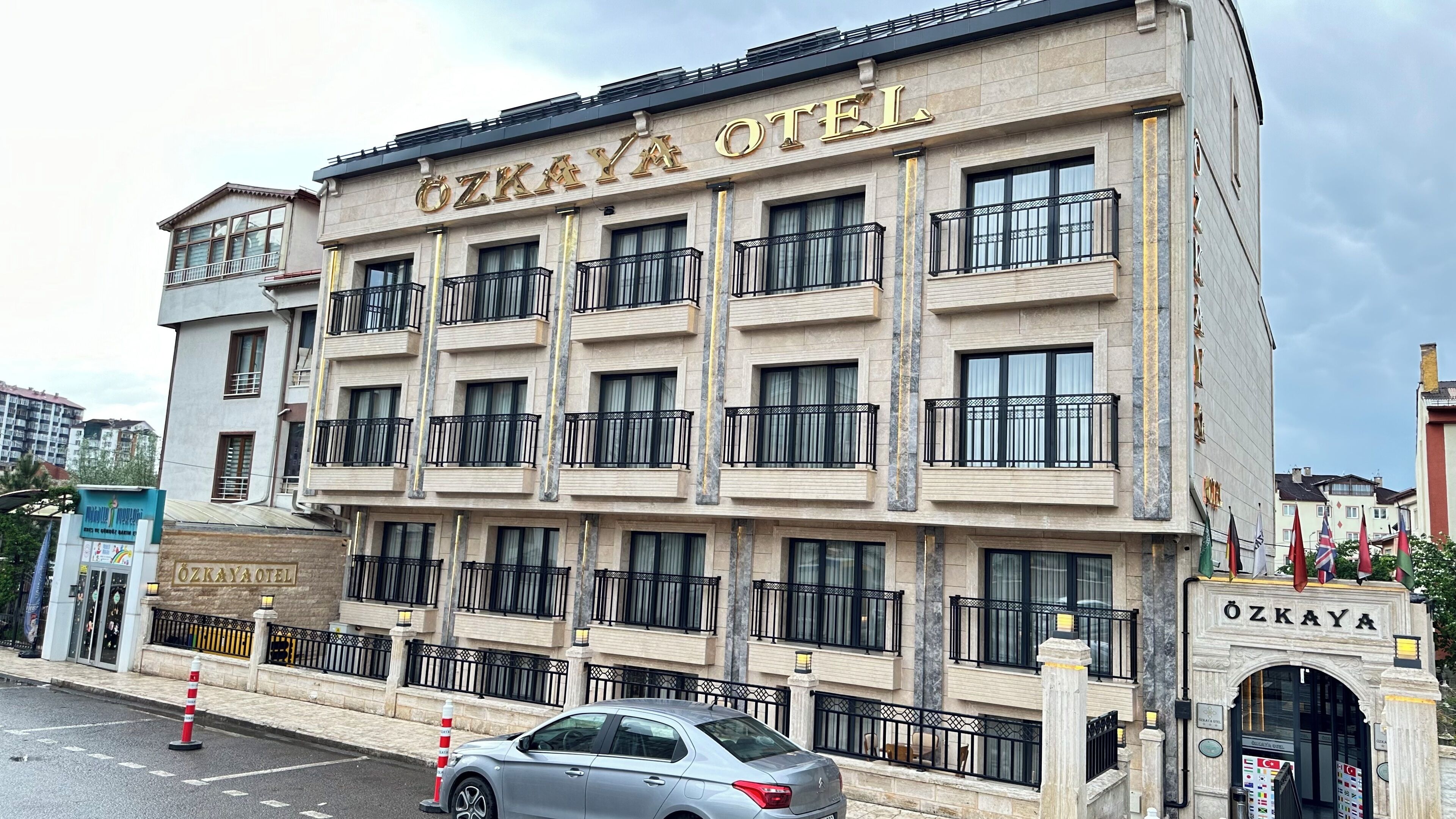A multi-story hotel with balconies and a sign reading "ÖZKAYA HOTEL".