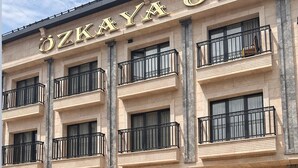 A building with a sign reading "ZKAYA HOTEL" and a black car parked in front. - Ozkaya Otel (Sivas)