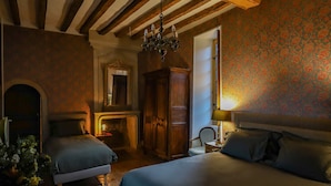 Ein Schlafzimmer mit zwei Betten, einem Holzschrank, einem Spiegel und einer Chandelier.