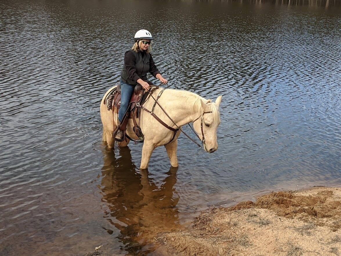 A person riding a horse through a body of water.