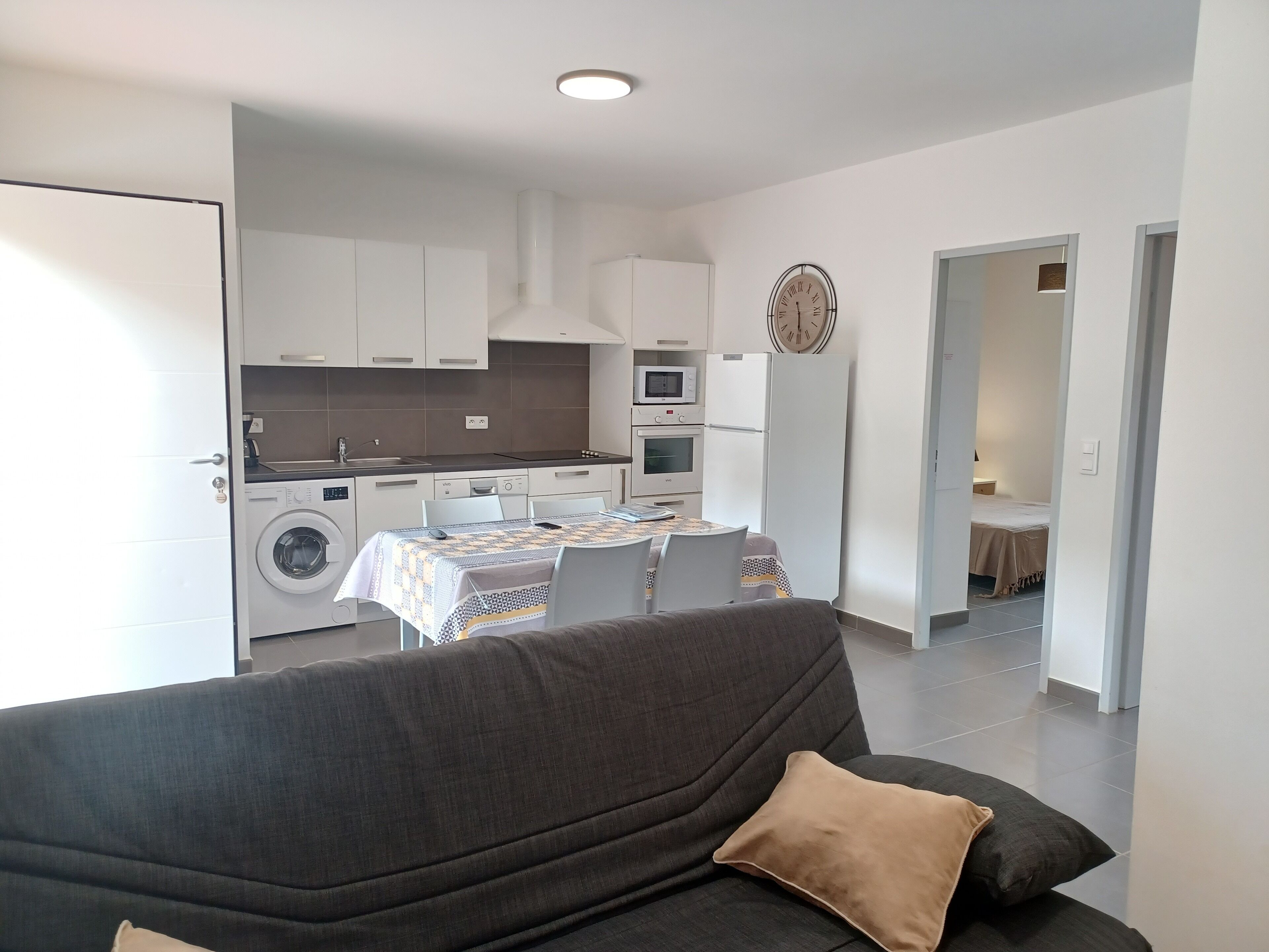 A modern apartment with a living room, a dining area, and a kitchen.