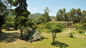 A rustic building with a stone facade, surrounded by lush greenery and trees. - New eco-certified house near the beach (Galéria)