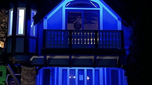 Ein zweistöckiges Haus mit Balkon, sichtbarem Deckenventilator und Eingangstür.