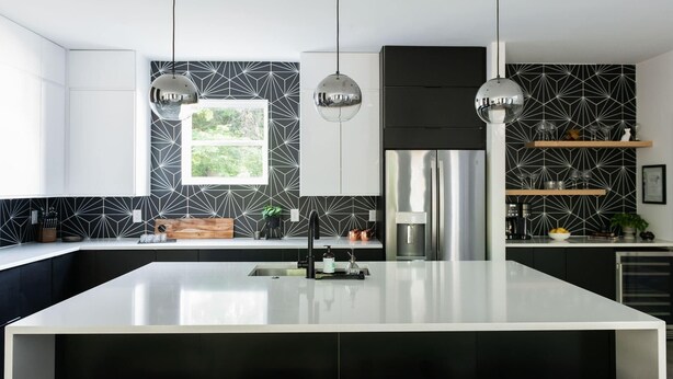 A modern kitchen with a central island, black and white patterned backsplash, stainless steel appliances, and pendant lighting. - Gated Luxe Home with Rooftop, Bunk Room, & Parking  |  Sleeps 10 with King Suite, Queen Rooms & Custom Bunks, Chef’s Kitchen w/ Wine Fridge,  Rooftop Patio, Dog Friendly, Dedicated Parking, Mins from Downtown and Broadway, 24 Hour Hospitality (Nashville)