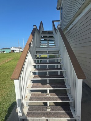 A wooden staircase with white railings leading to a building.