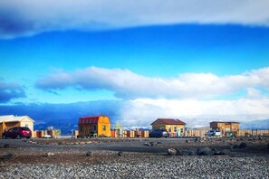 Un paisaje rural con varias casas de madera y un camino de grava.