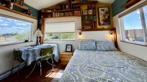 Een gezellige slaapkamer met een bed, een bureau en een boekenplank vol boeken.