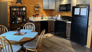 Un interior de madera con una cocina, que incluye armarios, un microondas y un refrigerador.