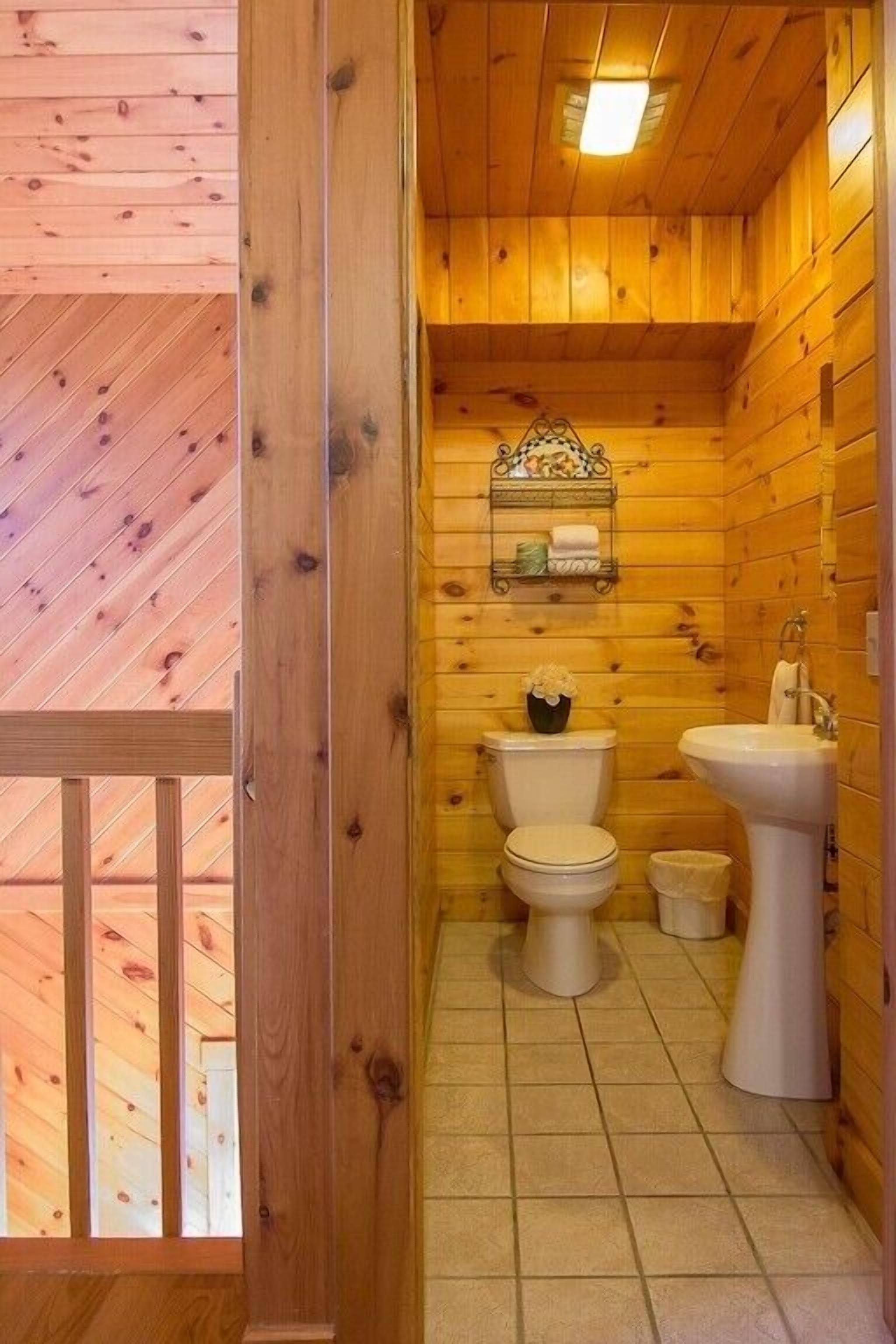 A wooden-paneled bathroom with a toilet, bidet, and shelf with toiletries.