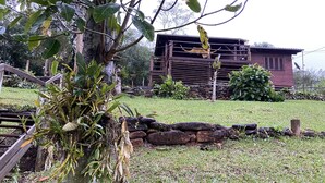 Un jardin avec un bassin, une clôture en bois et un mur de pierres.