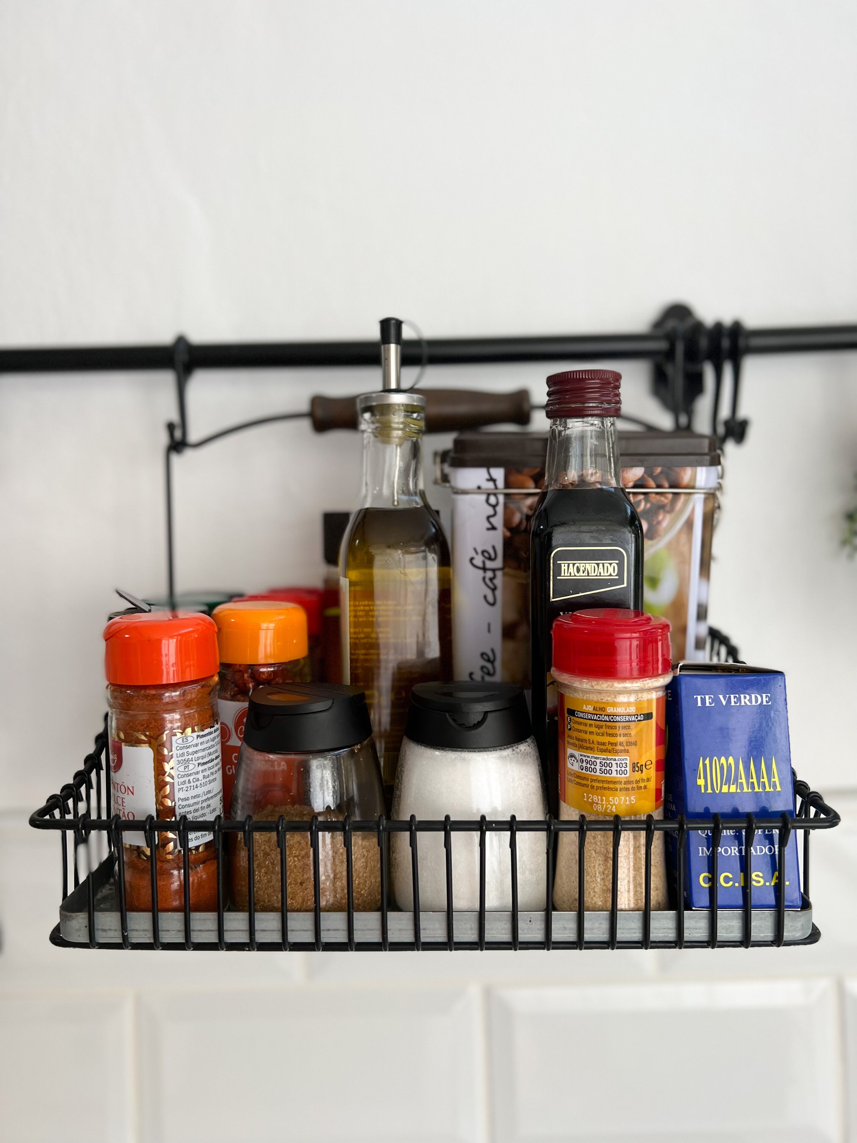Un mueble de especias con varios recipientes y una botella de miel.