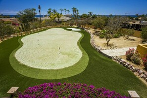 A golf course with a well-manicured fairway, sand bunkers, and a water hazard.