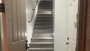A staircase with carpeted steps leading to a landing.