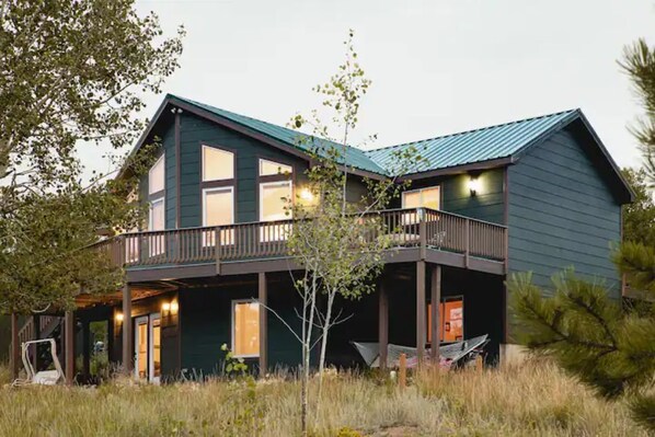 A two-story house with a balcony and a covered porch area. - Amazing Views--Spacious 3BR, outdoor barrel sauna, dog friendly (Hartsel)