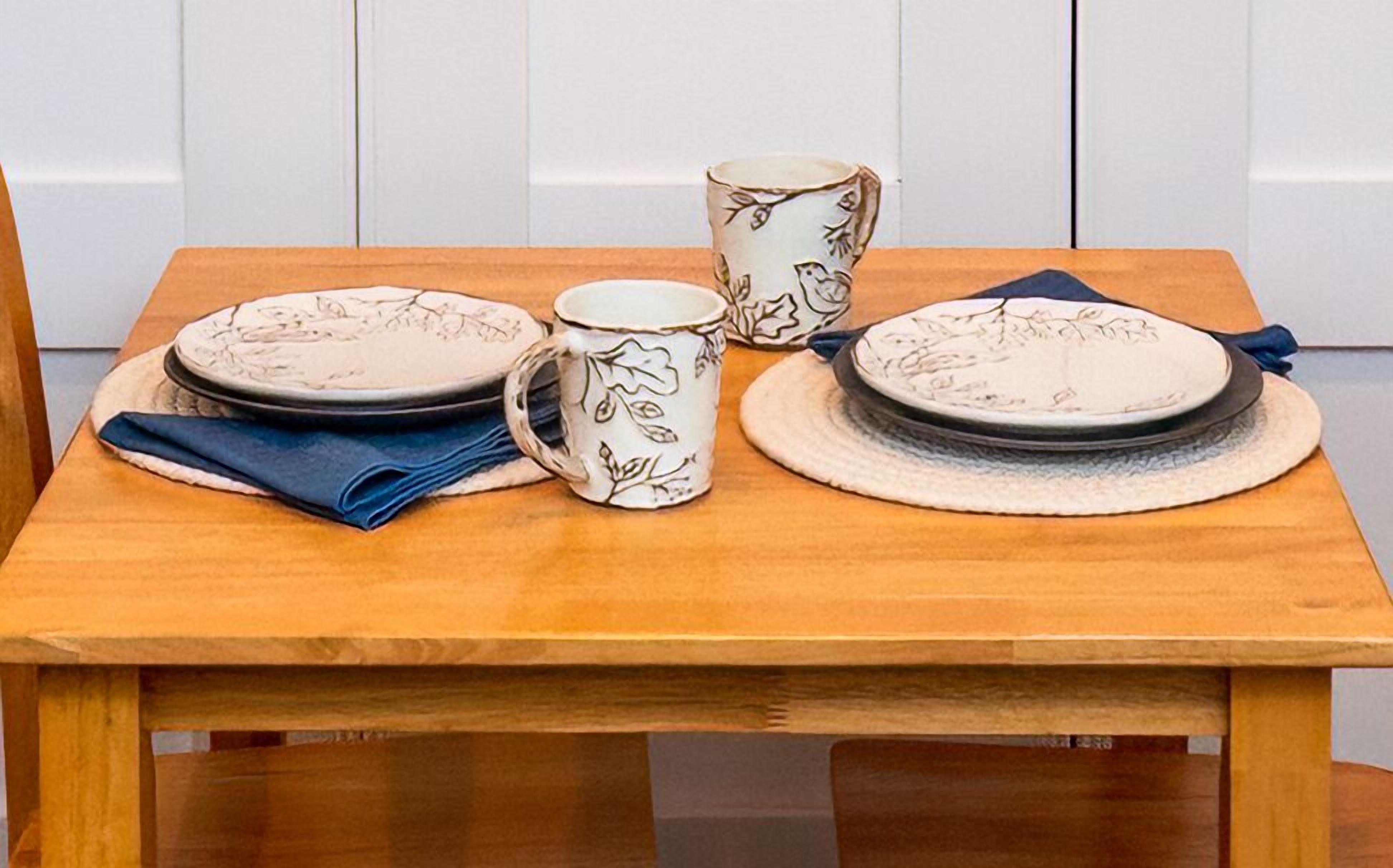 Ein Holztisch, gedeckt mit Tellern, einer Tasse und einem Servietttuch.