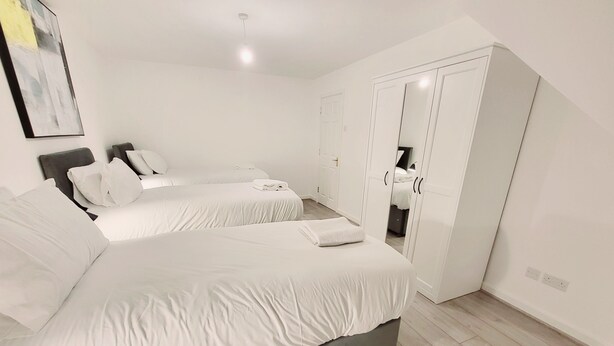 Ein Hotelzimmer mit zwei Betten, einem Kleiderschrank und einer Deckenleuchte.