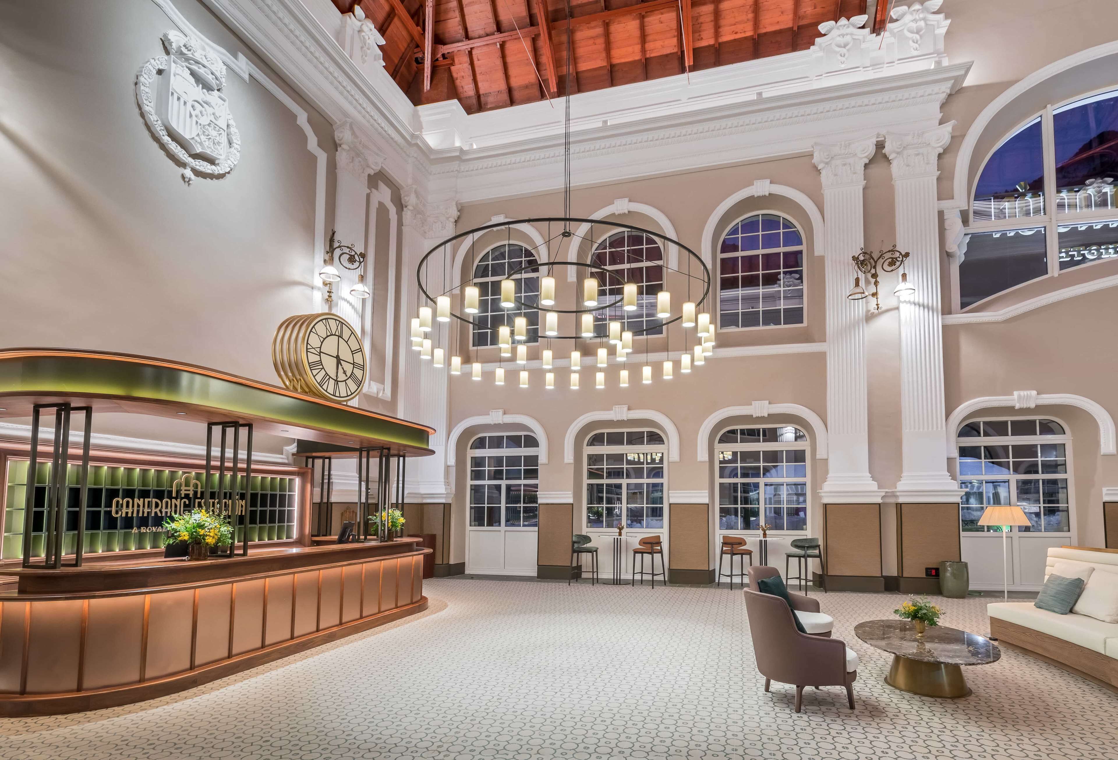 A grand lobby with a reception desk, seating area, and large windows.