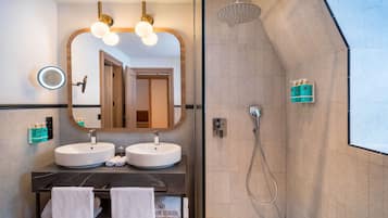 Une salle de bain moderne avec deux lavabos, un grand miroir et un espace douche.