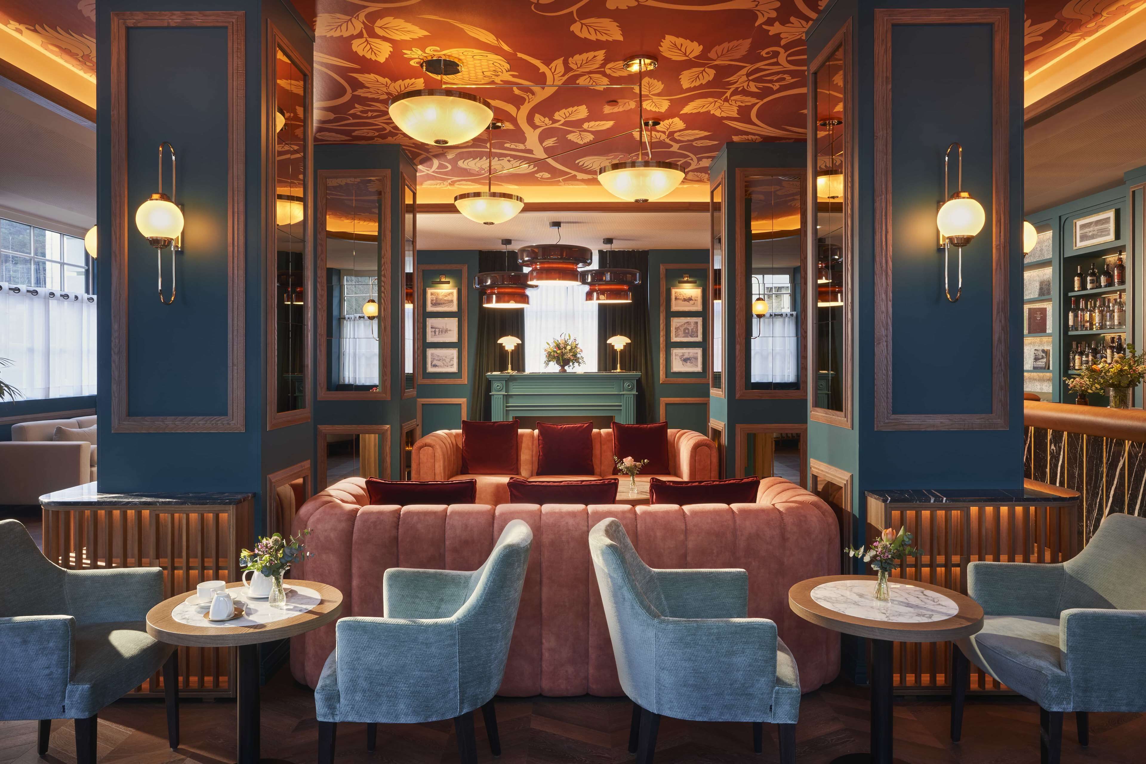 A luxurious lounge area with plush seating, a bar, and elegant lighting fixtures.