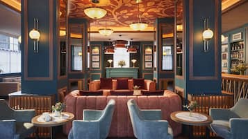 A luxurious lounge area with plush seating, a bar, and elegant lighting fixtures.