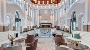 A spacious lobby with high ceilings, chandeliers, and a reception desk. - Canfranc Estación, A Royal Hideaway Hotel - Gran Lujo (Canfranc)
