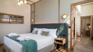 Habitación de hotel con una cama grande, una mesita de noche, un espejo y vistas al pasillo.