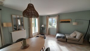A living room with a dining table, sofa, and a large window. - Large, comfortable house with exceptional mountain views (Laruns)