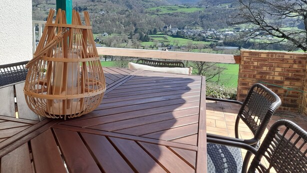 A wooden table with a woven basket on a balcony overlooking a mountainous landscape. - Large, comfortable house with exceptional mountain views (Laruns)