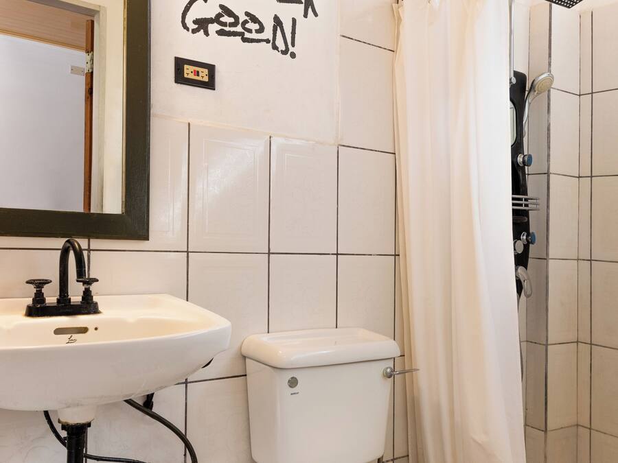 Un baño con lavamanos, inodoro y ducha.