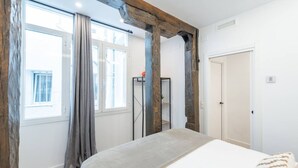A bedroom with a bed, a wardrobe, and a window with curtains. - 1)The Heart Of The City, Sol, By MoNARO (Madrid)
