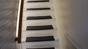 A staircase with white steps and black risers, leading upwards. - Carey Way Quarters-Stylish 3BR Loft-Prime Location (Pittsburgh)