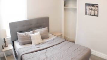 2 habitaciones, escritorio y tabla de planchar con plancha