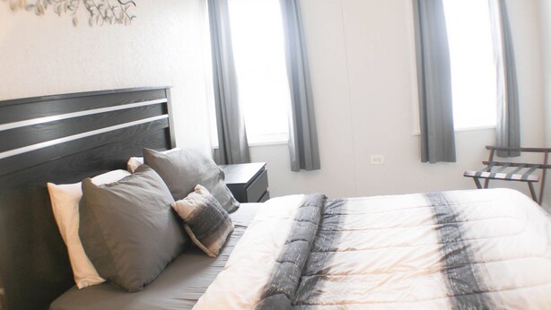 Une chambre à coucher avec un lit, des tables de chevet et une chaise.