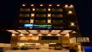 Een hotel met een moderne gevel, een opvallend 'SureStay by BEST WESTERN'-bord en een goed verlichte entree.