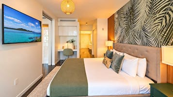Une chambre d’hôtel dotée d’un grand lit, d’un téléviseur diffusant des images de paysages, d’un bureau avec une chaise et d’un panneau décoratif mural.