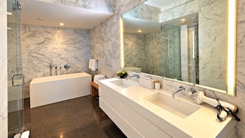 Une salle de bain moderne avec une grande baignoire blanche, un meuble-lavabo à deux vasques et un grand miroir.