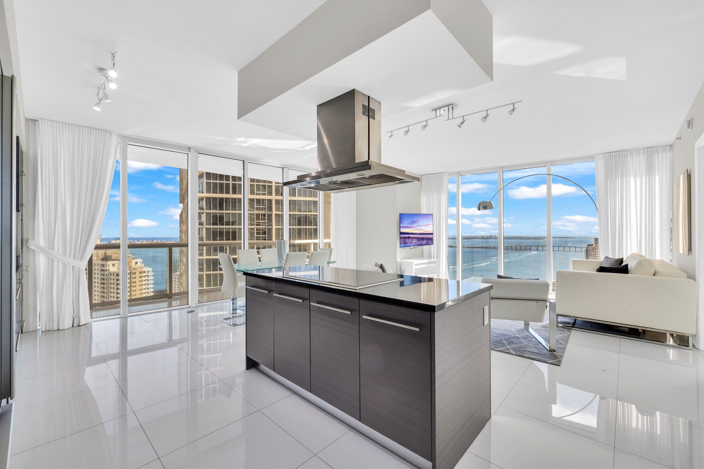 Eine moderne Küche mit einer zentralen Kochinsel, großen Fenstern und Blick auf die Stadt.