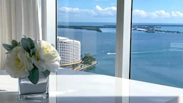 A view from a window overlooking a body of water with a large building and a dock.
