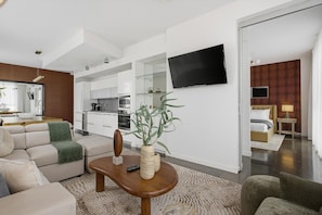 Una sala de estar moderna con un sofá, una mesa de centro y un televisor montado en la pared.