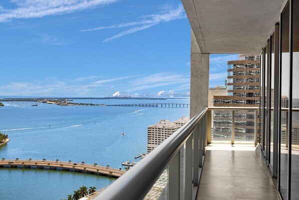 A balcony with a view of a body of water, a bridge, and a cityscape.