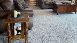 A cozy log cabin interior with two sofas, a wooden coffee table, and a lamp. - Moonlight Ridge Cabin (Ennis)