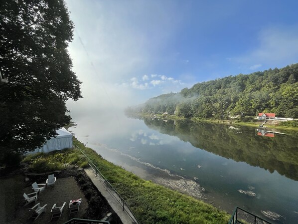 A serene lakeside view with a clear sky, a dock, and a row of houses along the water's edge.